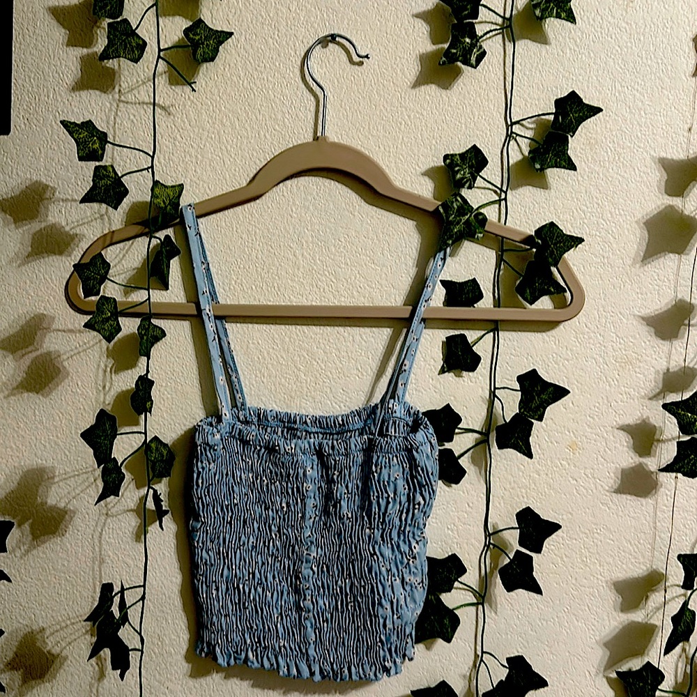 This is a string crop top. It has a design of tiny white flowers. Color is blue.